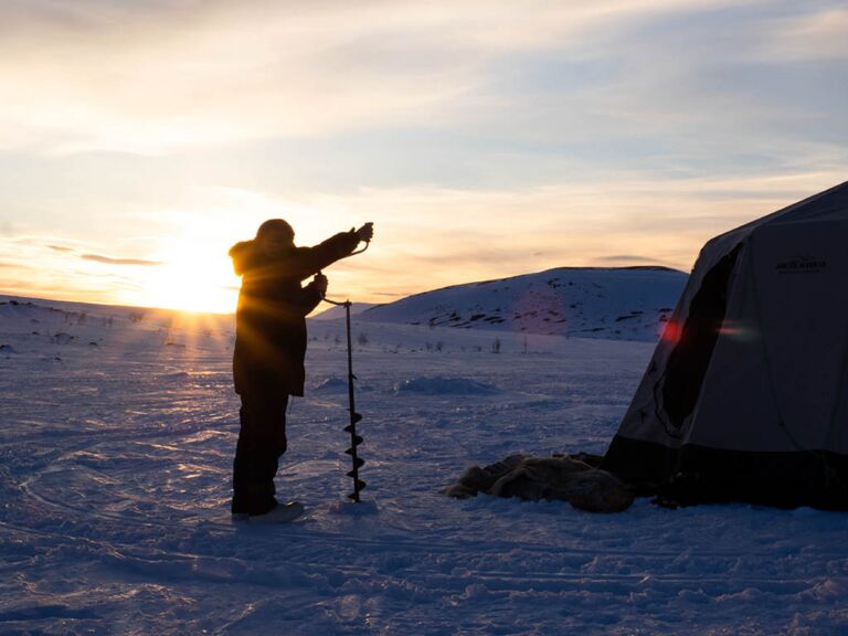Ice fishing drilling in Swedish wilderness